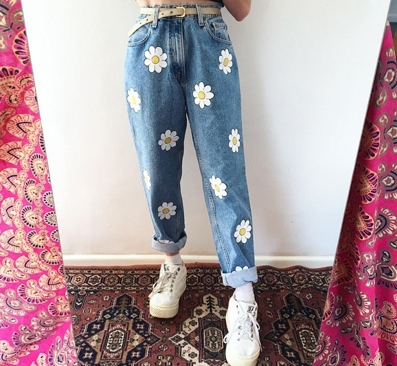 Nærbilde av broderte tusenfryd på lommen av damejeans med høy midje og klassisk rett passform.
