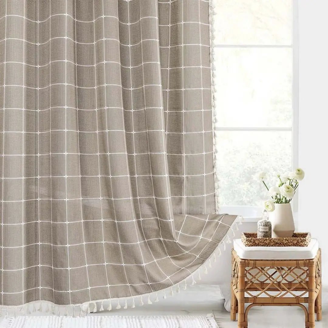 Stilrent hvitt boho dusjforheng med dekorative håndlagde dusker, perfekt for baderomsinteriør.