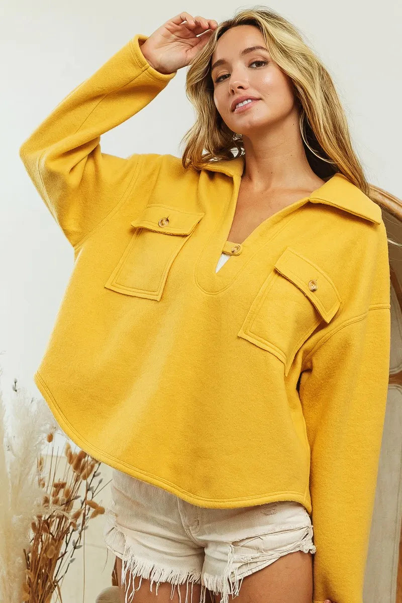 Nærbilde av krage og lommer på en moderne dame sweatshirt. Kvalitet og detaljer for en komplett hverdagsstil.