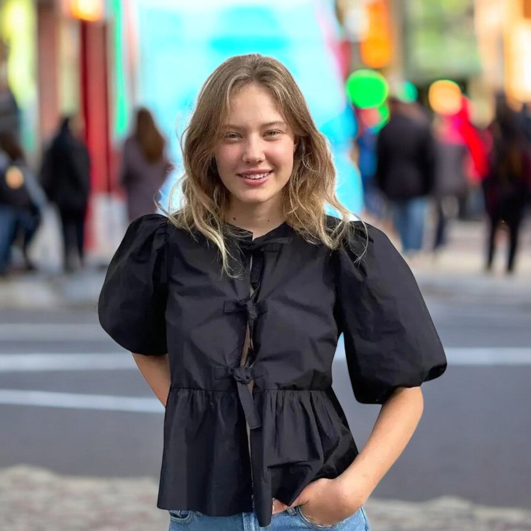 Trendy damebluse med stilige puffermer og justerbar snøring. Perfekt for en casual chic look.