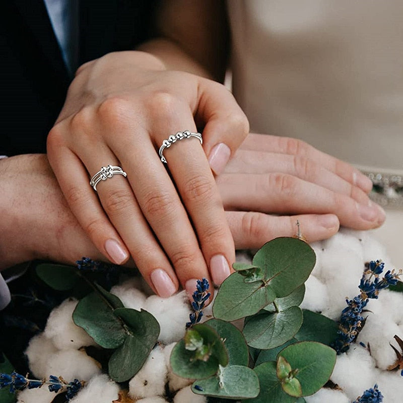 Eleganter Damen Fidget Ring, Anti-Stress-Schmuck mit drei drehbaren Perlen auf einer schlanken Ringschiene.