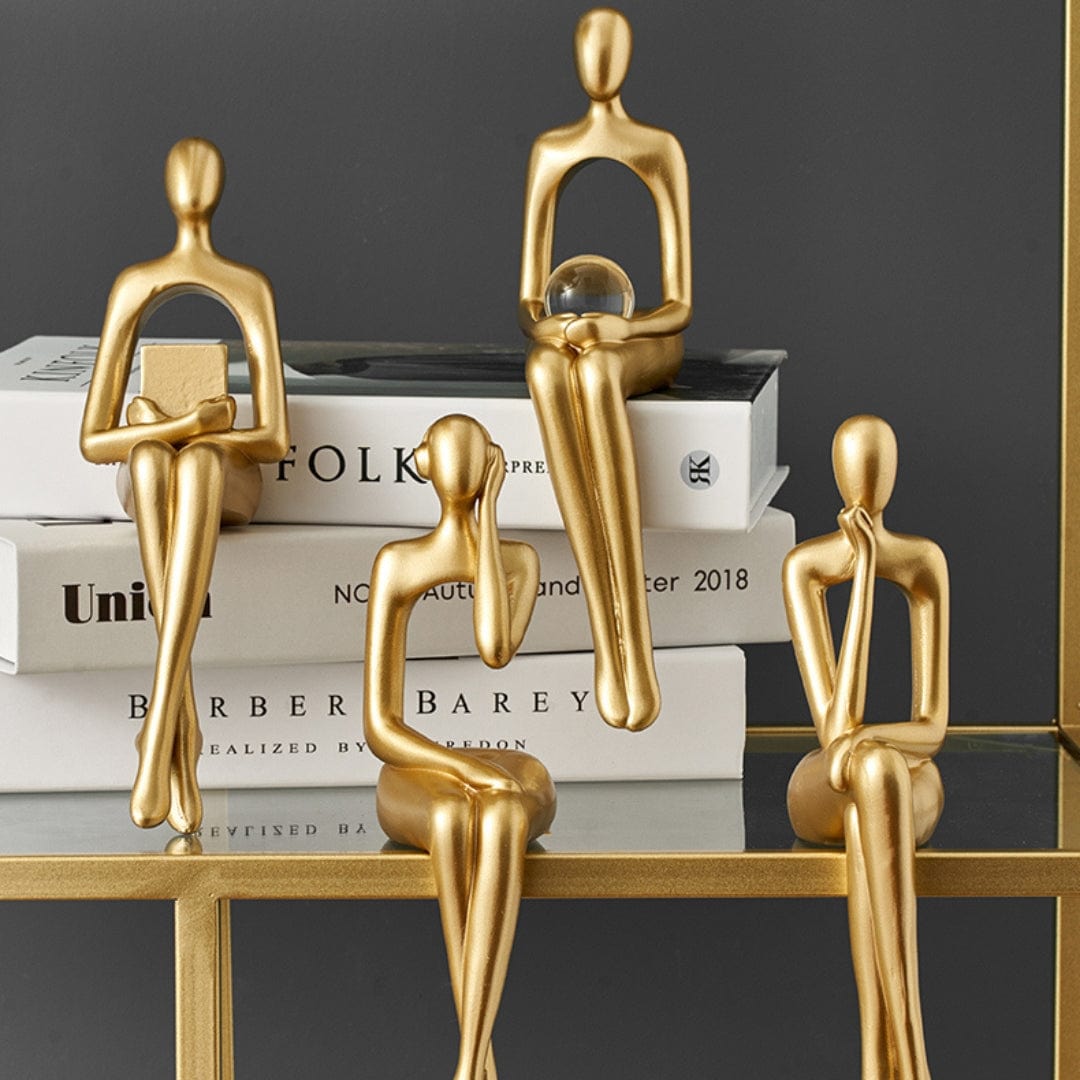 To moderne abstrakte statuer pynter en bokhylle i stuen. Stilfull hjemmedekorasjon.