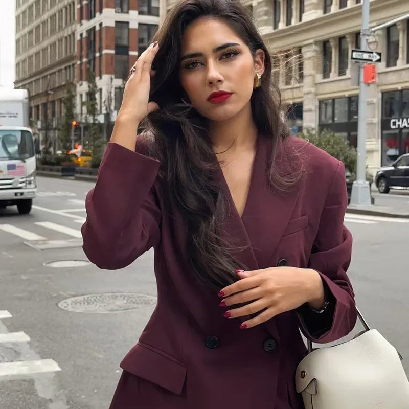 Nærbilde av dobbelknappet burgunder dameblazer med stilrene knapper. Perfekt skreddersydd for en elegant look.