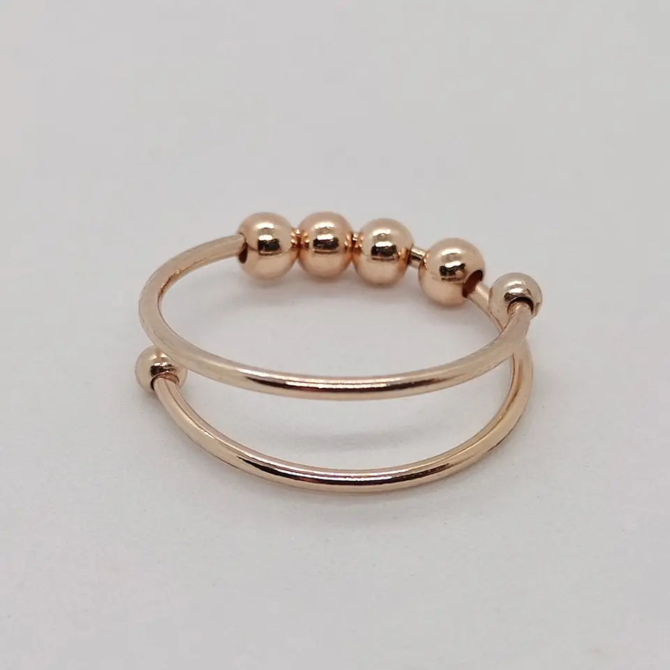 Roségull antistressring for kvinner, med elegant roterende design for beroligende effekt og økt fokus. Kvinnering.