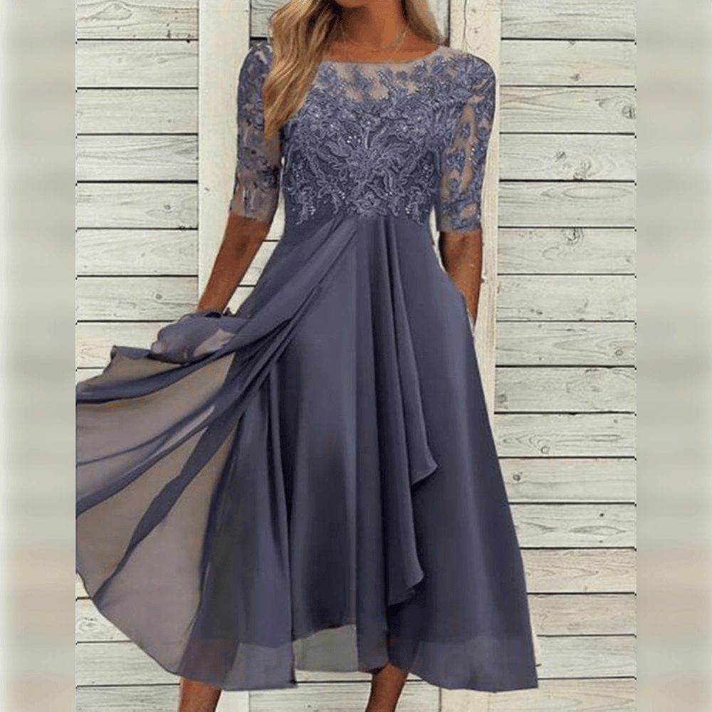 Modell iført elegant kvinners asymmetrisk maxi kjole, perfekt for en luftig og stilig look.