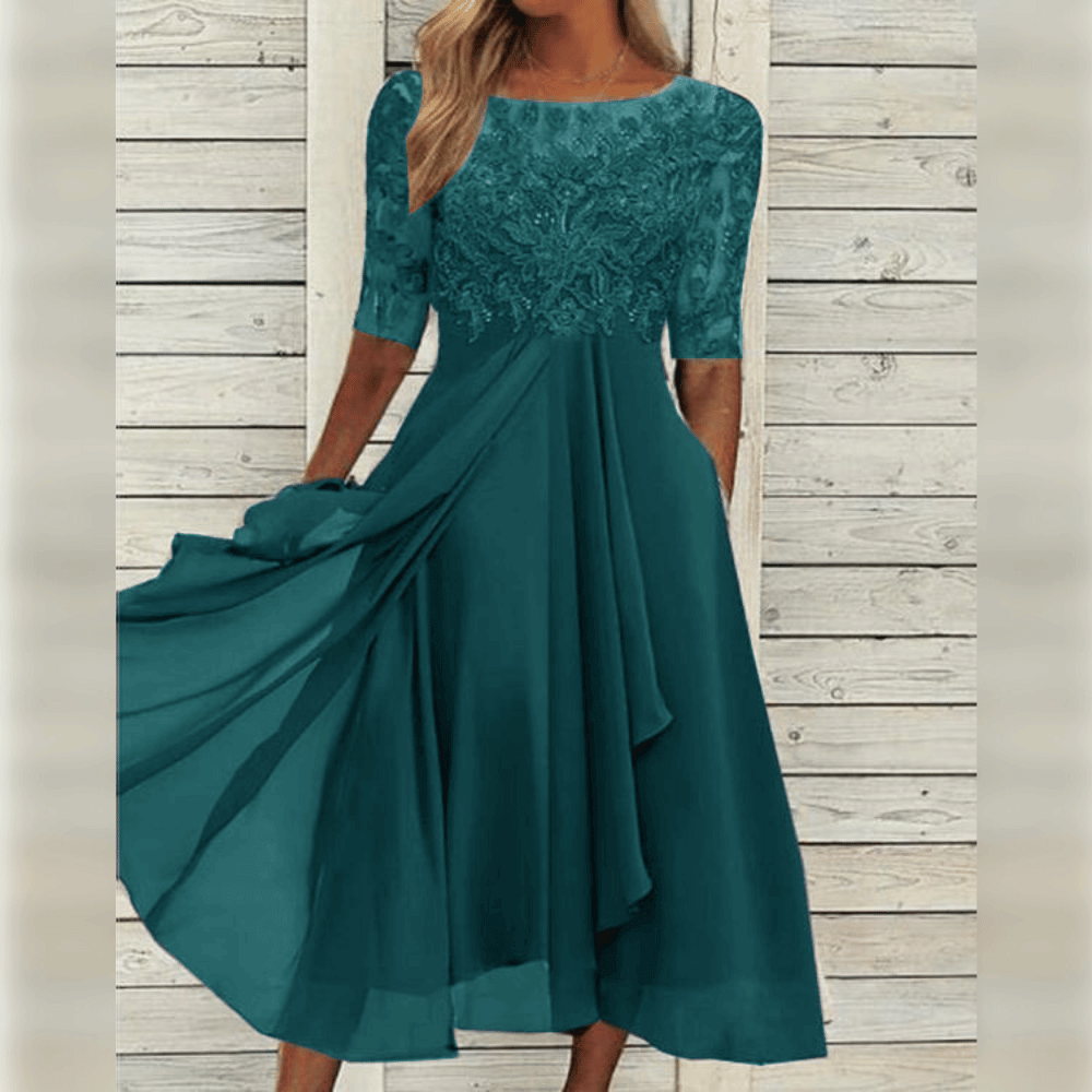 Nærbilde av stoffet på en elegant asymmetrisk A-linje maxi kjole, viser luftig kvalitet.