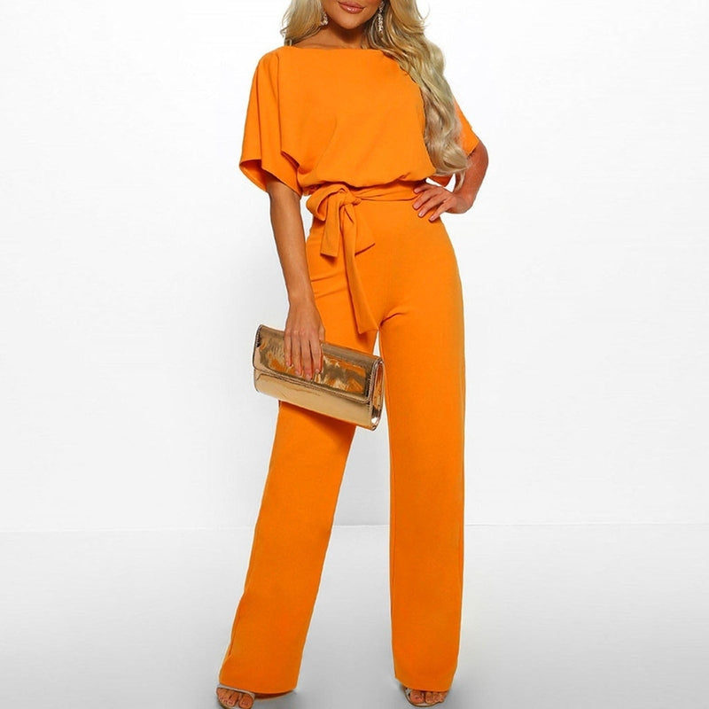 En kvinne poserer i en elegant, komfortabel jumpsuit med snøremidje og vide ben.