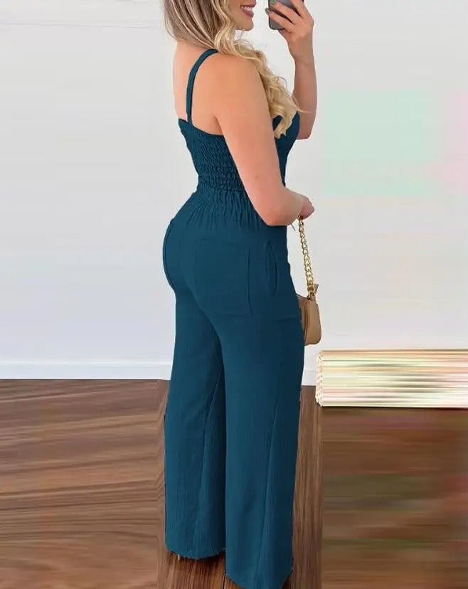 Ryggløs elegant jumpsuit for dame. Viser den stilige åpne ryggen med spaghettistropper, ideell for sommer.