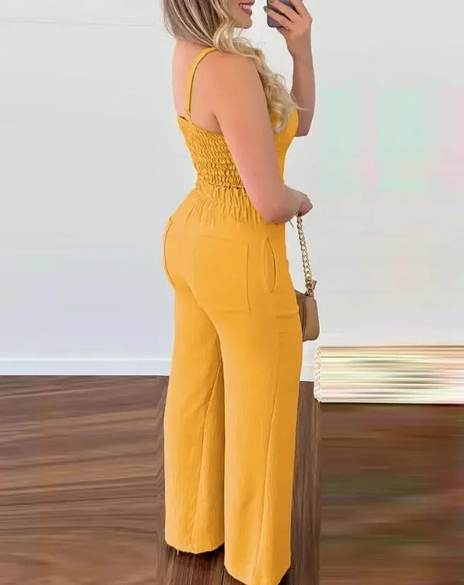 Dame jumpsuit med elegant fallende stoff, V-hals og spaghettistropper. Komfortabelt og stilrent sommerantrekk.