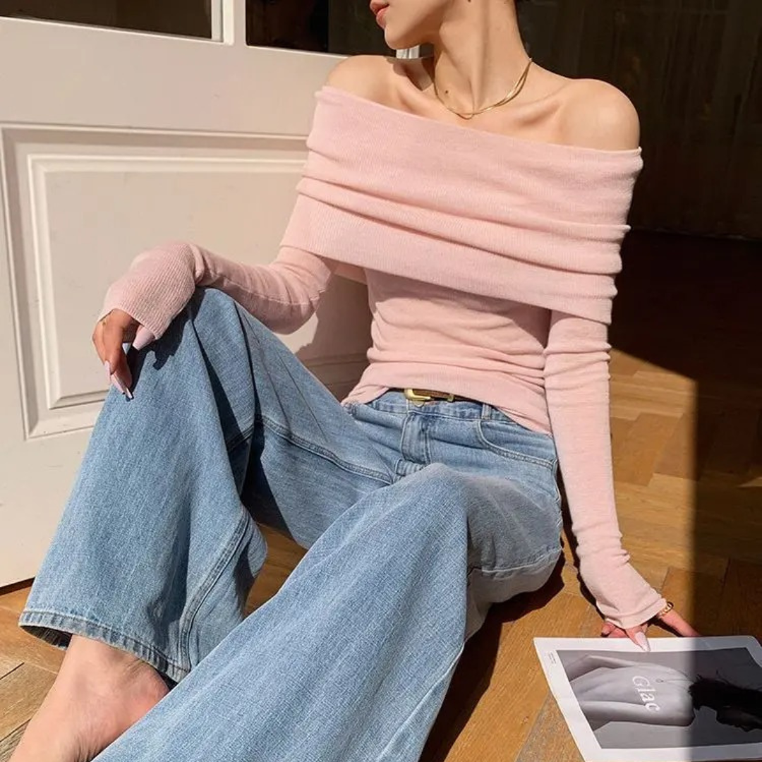 Detaljbilde av dame off-shoulder toppens slash neck og lange ermer, fremhever den elegante designen.