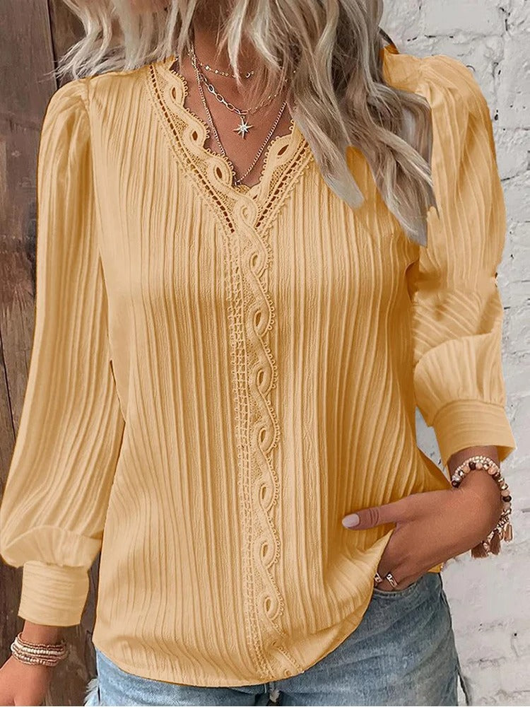 Elegant damebluse med V-hals, detaljerte blonder og en behagelig løs passform.