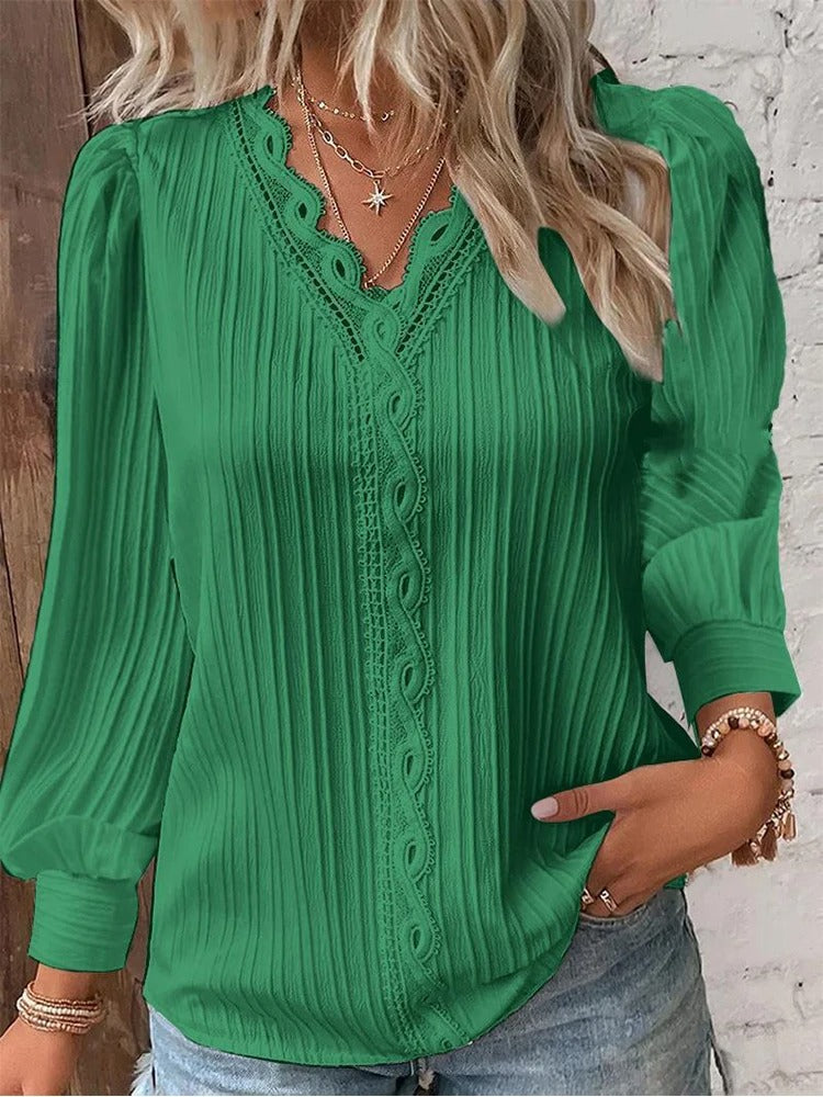 Damebluse med V-hals og delikate blonder. Løs passform for komfortabel hverdagsstil.