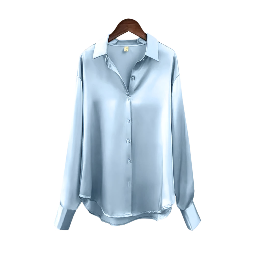 Elegant damebluse med knapper i en moderne vinkel, fremhever flott fall og klassisk stil.