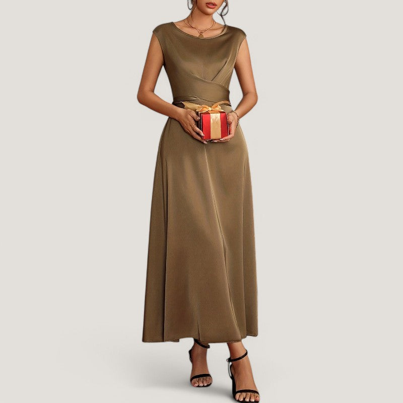 Tidløs beige sateng aftenkjole på mannequin. Ermeløs design for galla, bryllup og fest.
