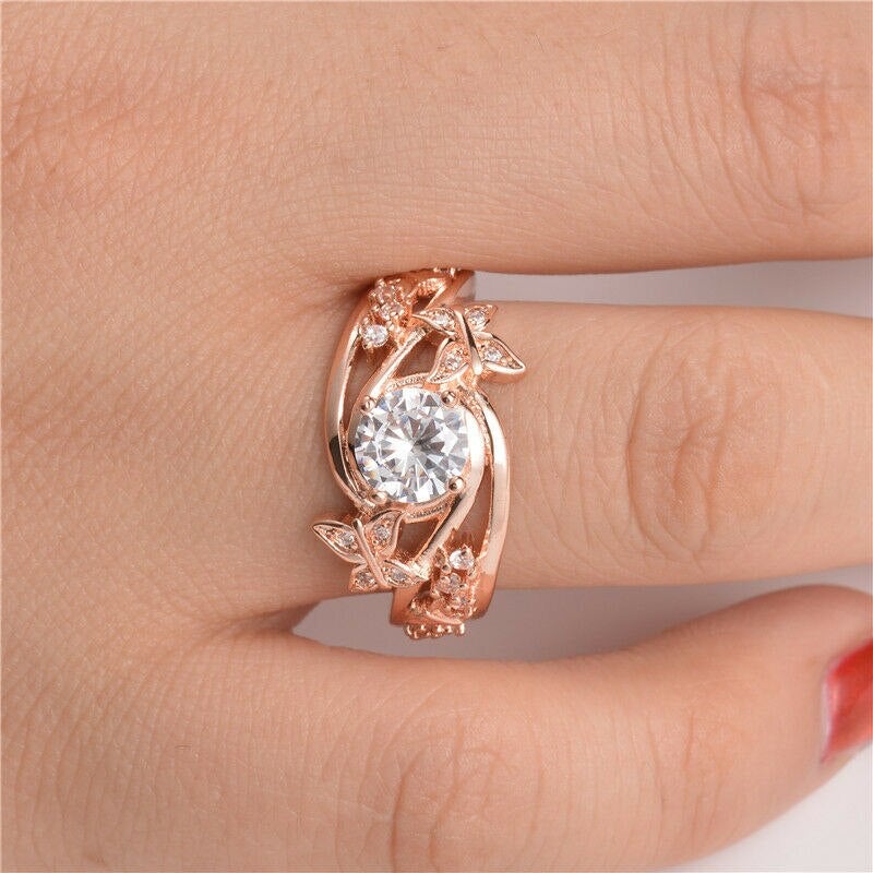 Intrikat gullbelagt sommerfuglring med blomster og gnistrende zirconia rhinestones. Elegant smykke til kvinner.