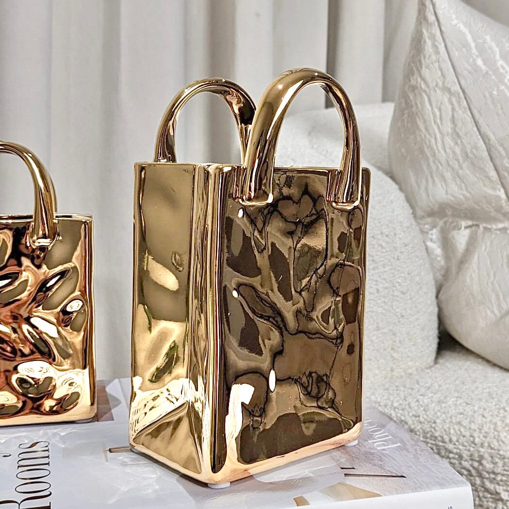 Glansfull gullvase formet som en elegant pynteveske, ideell for moderne interiør og stilfull dekor.