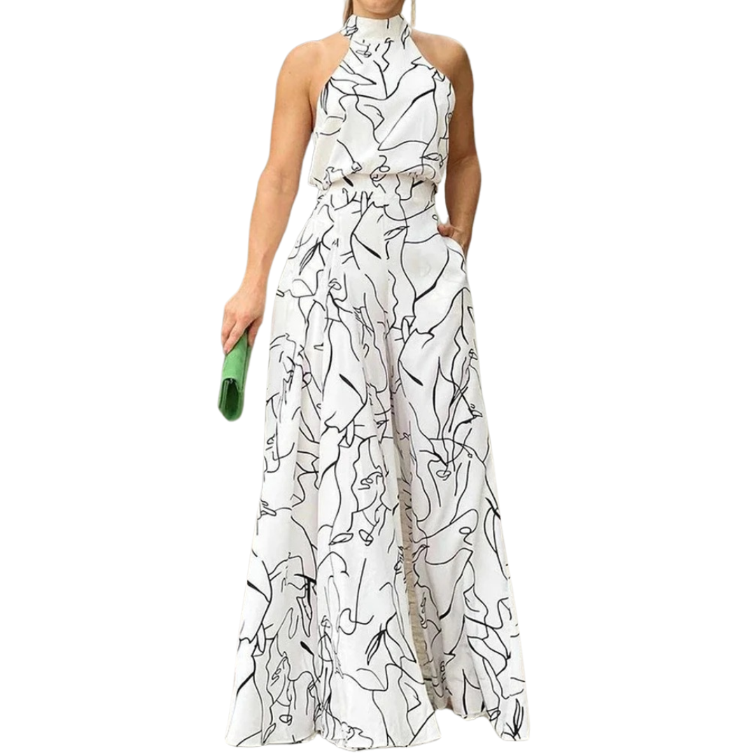 Elegant halterneck jumpsuit for kvinner med vide ben. Perfekt sommerstil og festantrekk i mønstret stoff.