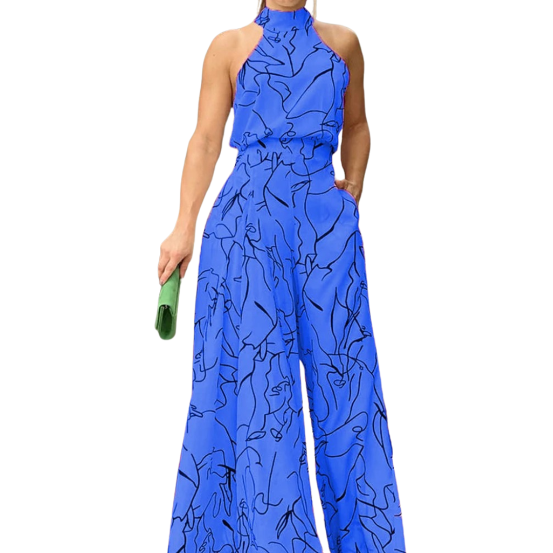Kvinne poserer i en elegant, mønstret halterneck jumpsuit, klar for sommerfest eller ferie.