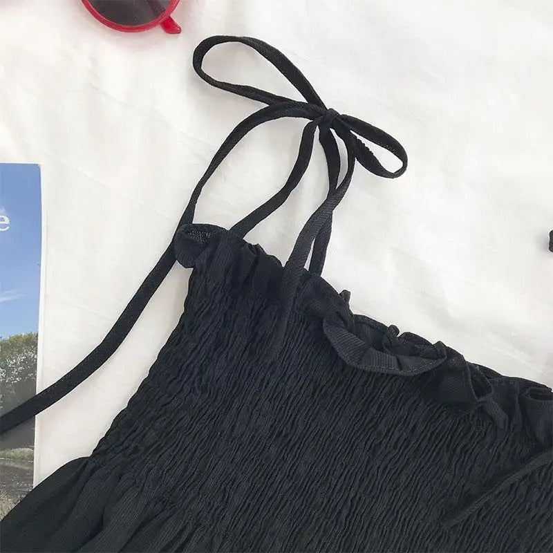 Motebevisst kvinne iført elegant halterneck topp. Plissert front og ryggfri stil for en sofistikert look.