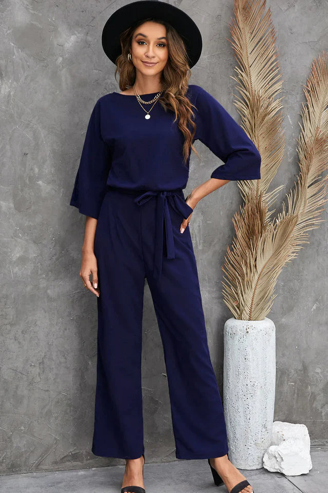 Nærbilde av elegant jumpsuit med brede ben og stilfullt midjebelte, fokus på detaljer.
