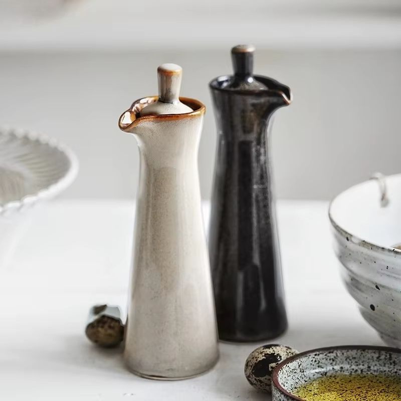 Stilfull keramisk flaske for olje og eddik, med elegant finish. Essensiell for matlaging og servering.