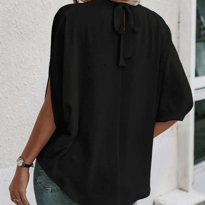 Komfortabel kvinnebluse med avslappet passform, halvlange ermer og trendy splitt, ideell for dagligbruk.