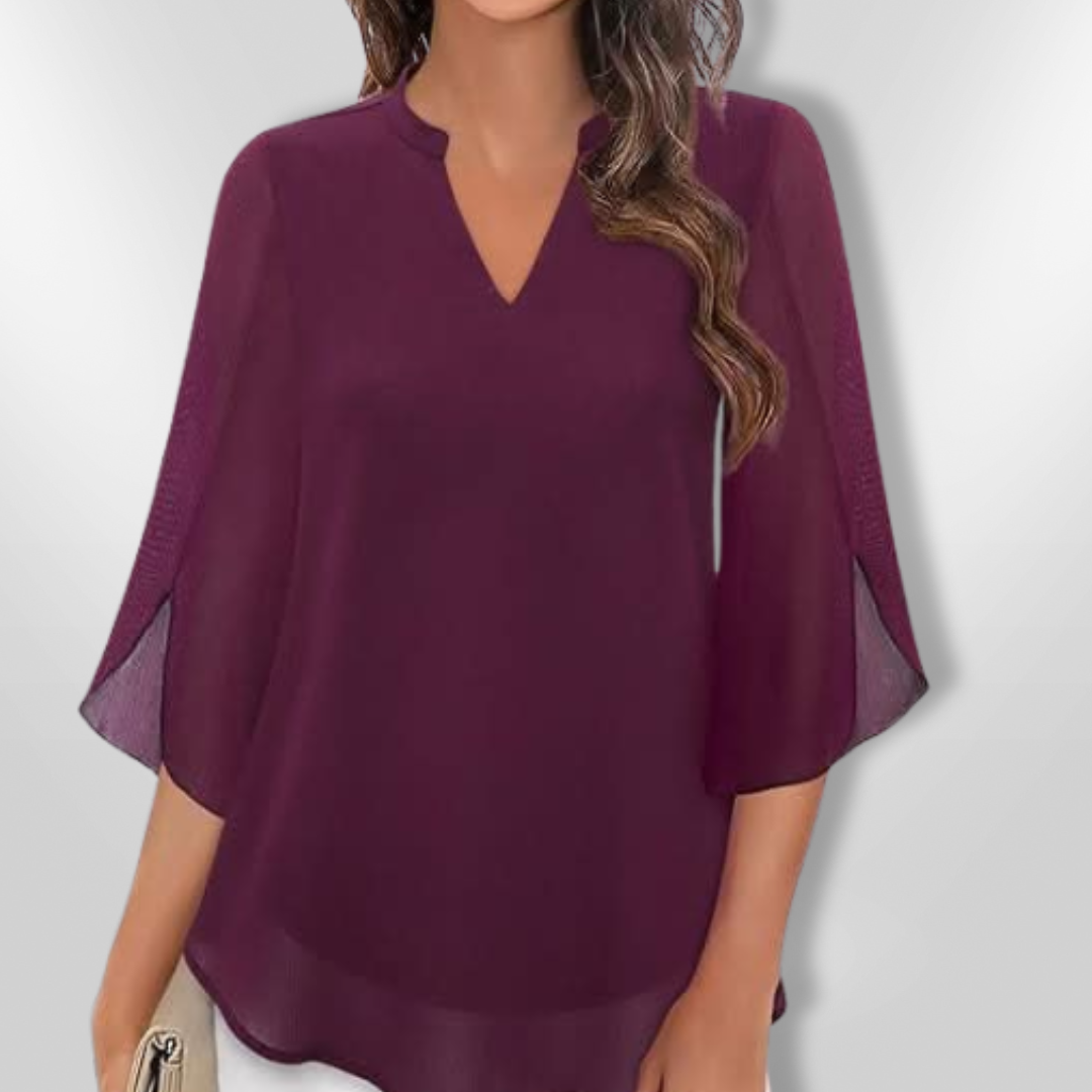 Detalj av elegant V-hals kvinnebluse med subtile lagdelte detaljer, som gir en sofistikert og komfortabel stil.