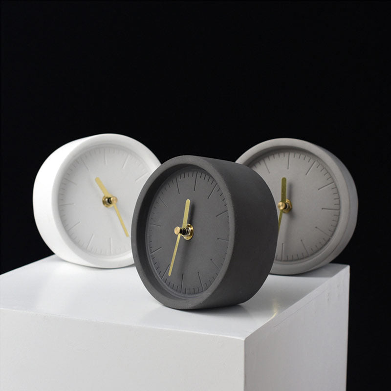 Nordisk designklokke på skrivebord. Sementstil gir et unikt, minimalistisk preg til hjemmedekor og interiør.