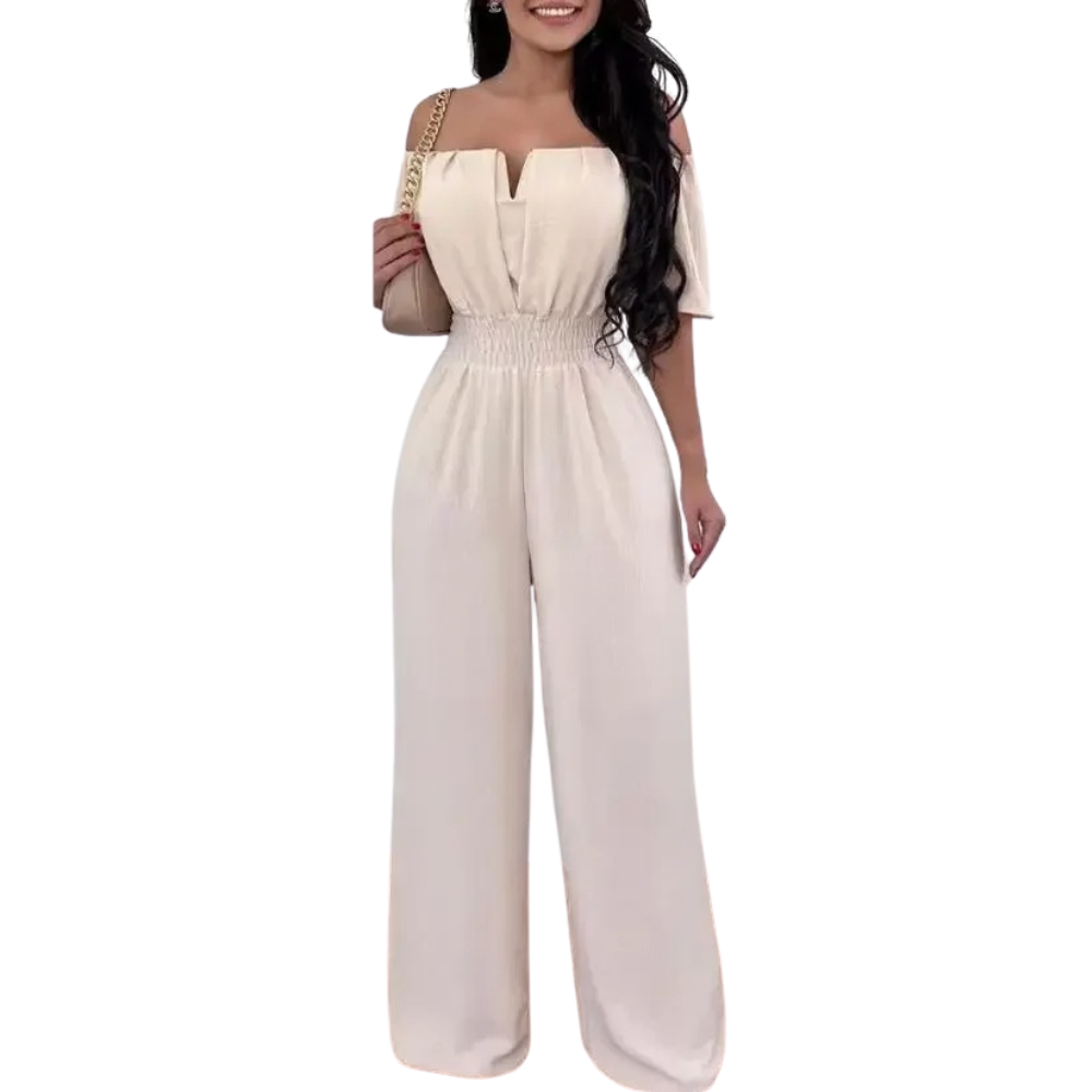 Elegant off-shoulder jumpsuit fra siden. Viser flytende silhuett og brede ben for en stilfull look.