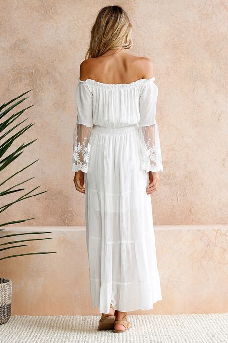 Lys blonde maxikjole med volanger og offshoulder-stil. Elegant langkjole.