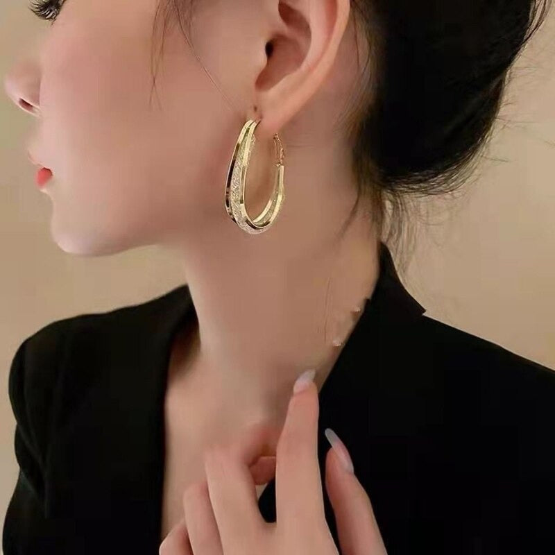 Ovale bøyleøreringer med zirconia, elegant tilbehør for kvinner, i både gullfarget og sølvfarget.