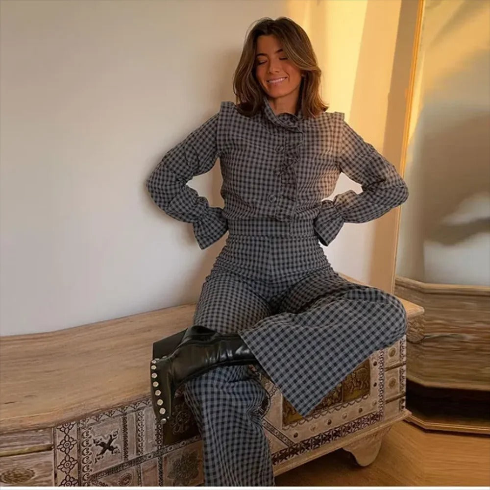 Ryggvisning av kvinner i komfortabel rutete jumpsuit med bobleermer. Moderne og elegant passform.
