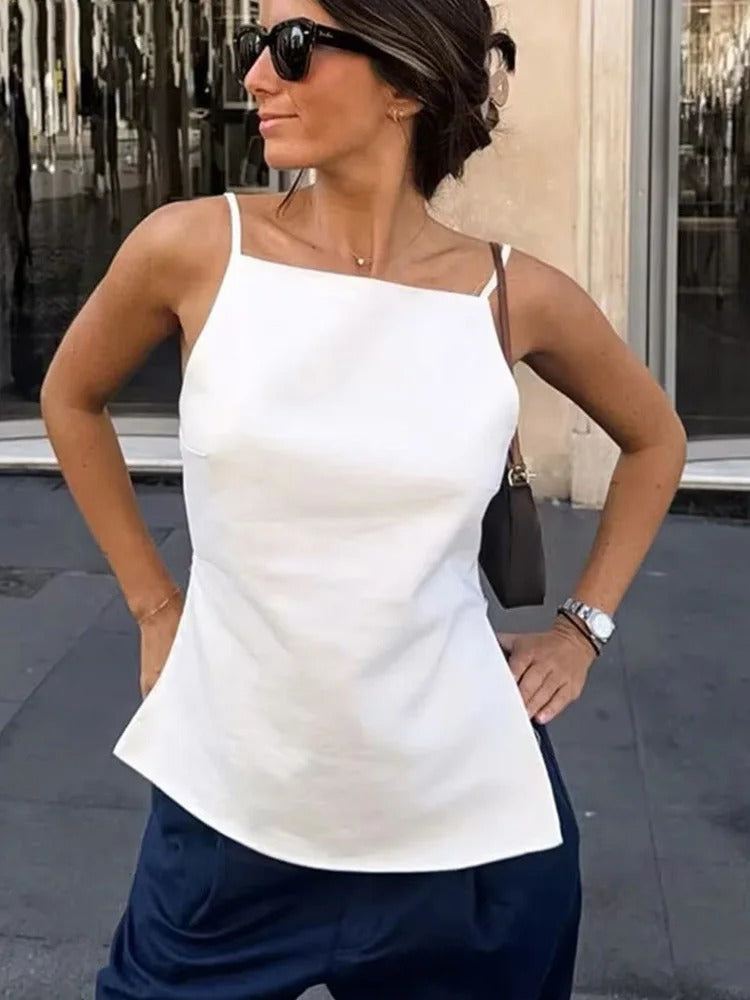 Kvinne i stilfull ryggløs crop top med tynne stropper, klar for sommerfest. Moderne og komfortabel.