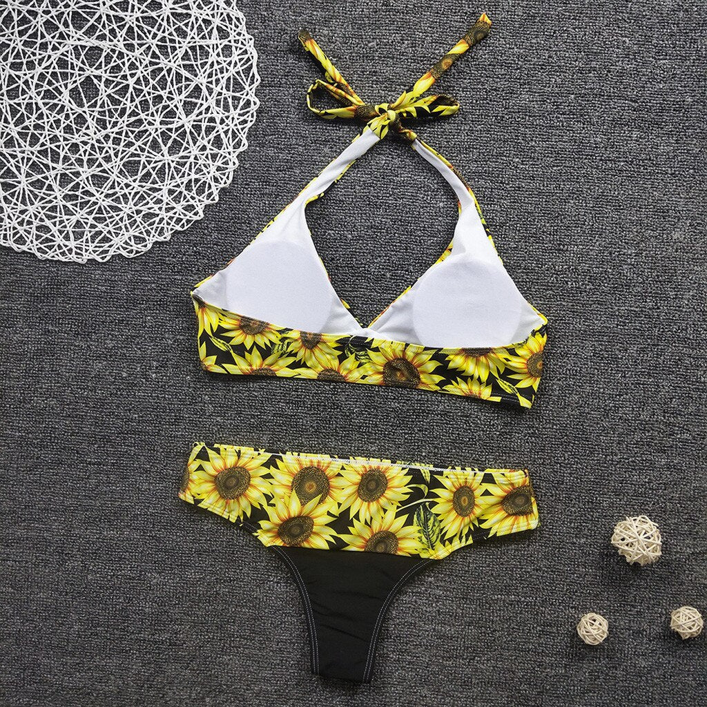 Sommerlig solsikke mønstret bikini for dame. Todelt badetøy med blomsterdetaljer, perfekt for strandbruk.
