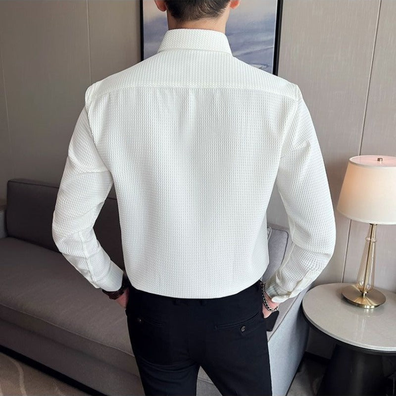 Formell herreskjorte med diskret struktur, lettstelt polyesterstoff og knapper, gir en skarp og polert look.