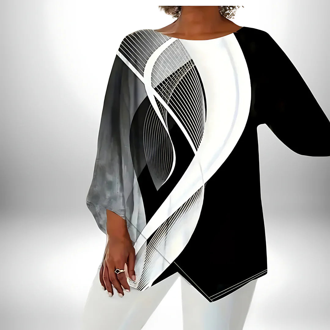 Langermet dametopp med asymmetrisk geometrisk design i svart og hvitt, ideell for høst og vinter.