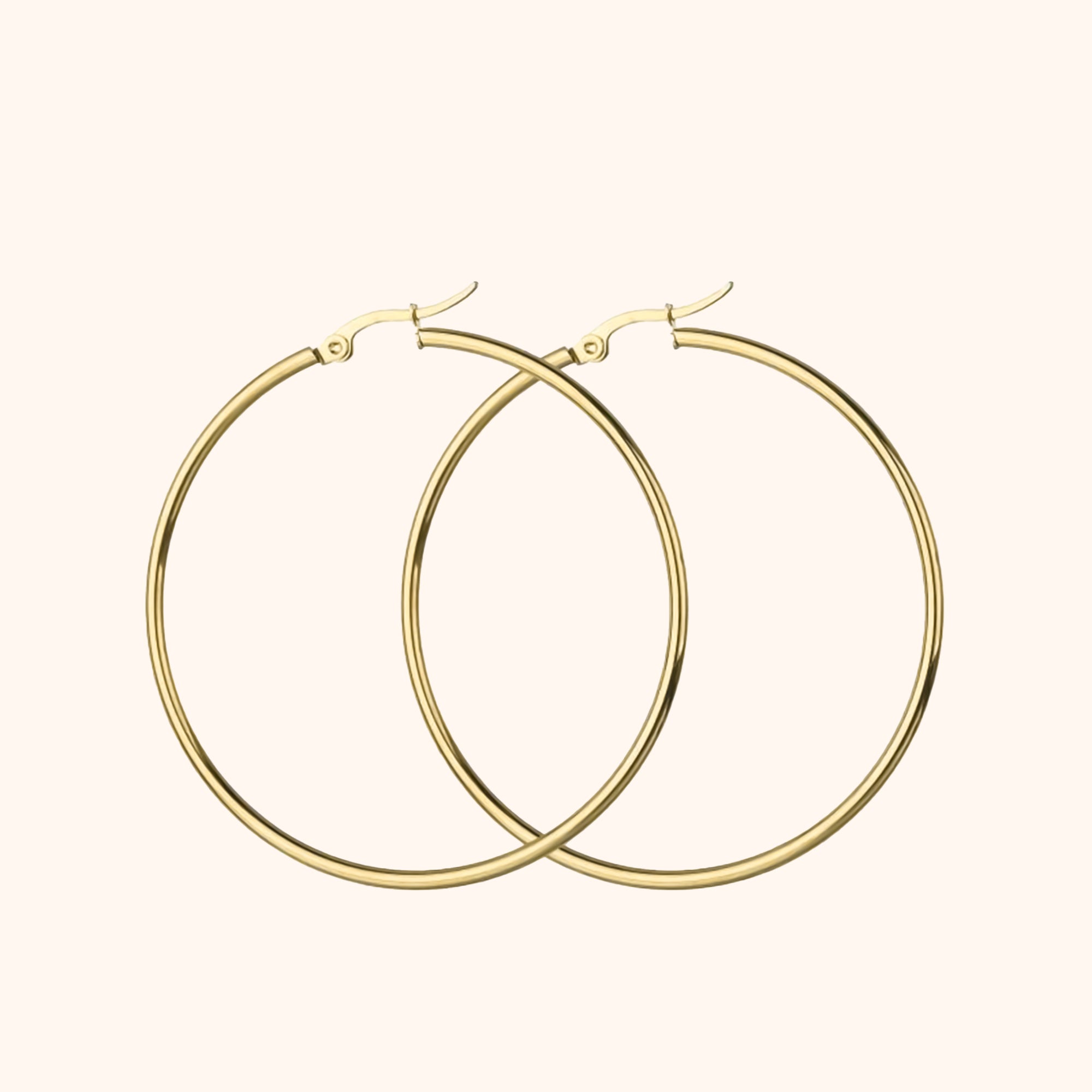 Kvinne bærer elegante og moderne sølv bøyleøreringer. Tidløst smykke med minimalistisk design.