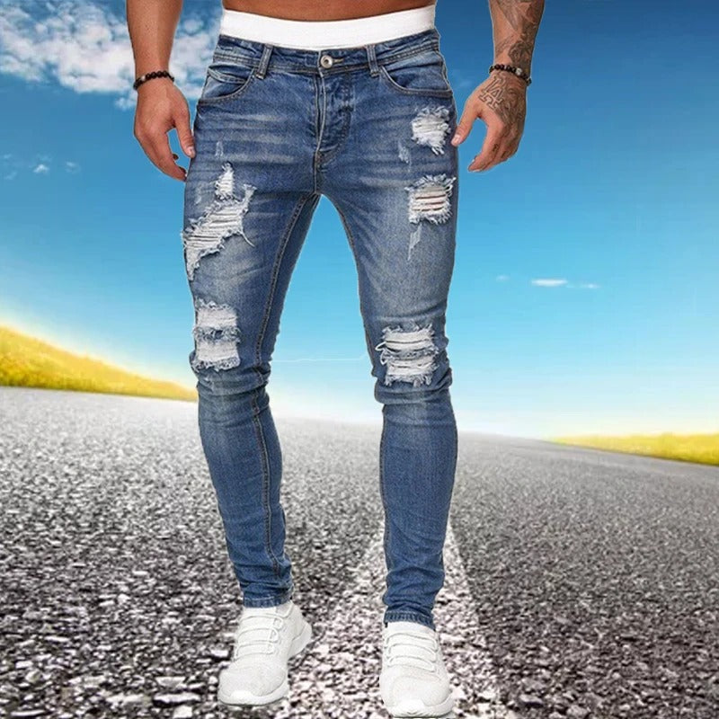 Ung mann som bruker stilige, slitte jeans med smal passform for menn
