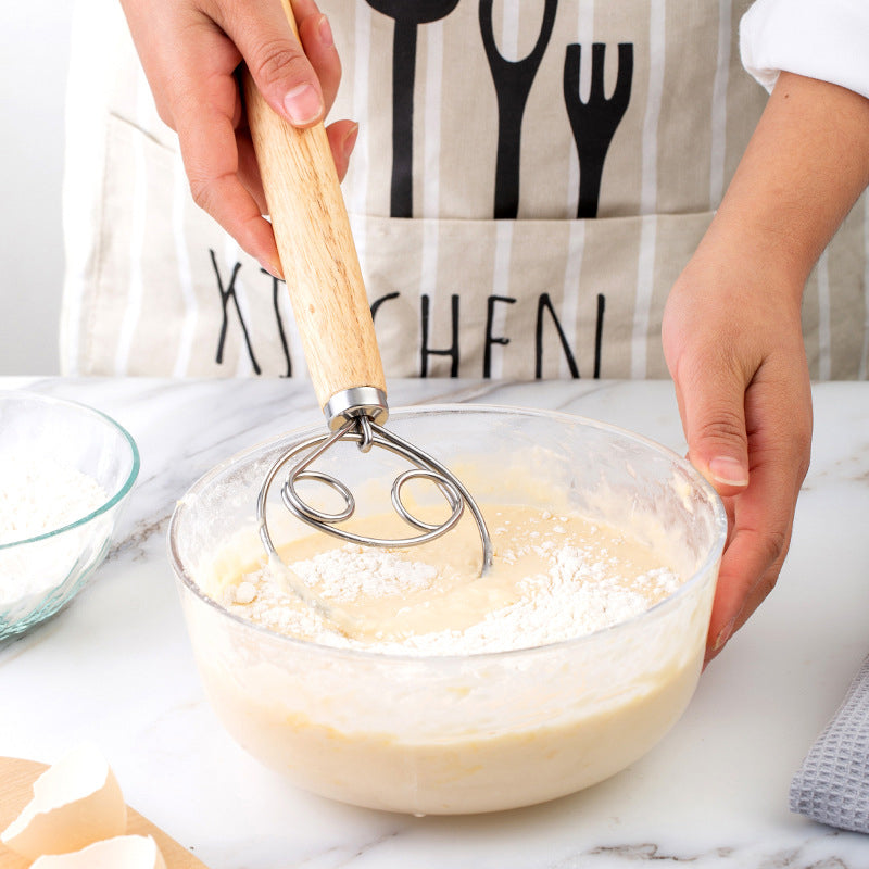 Ergonomisk deigvisp i rustfritt stål for effektiv blanding av deig til baking.