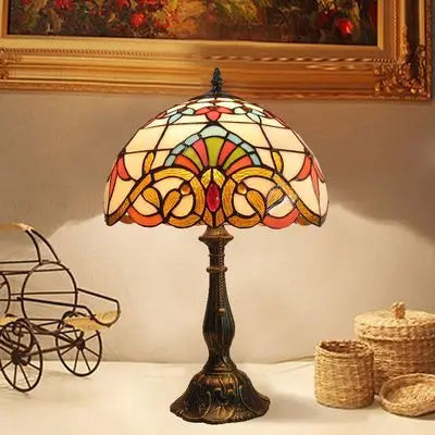 Elegant bordlampe med fargerikt glass og justerbar hals, perfekt som stemningslys og leselampe.