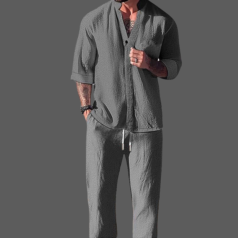Mann avslappet i loungewear-sett for menn: langermet V-hals-skjorte og komfortable bukser med snøring i gråmelerte.