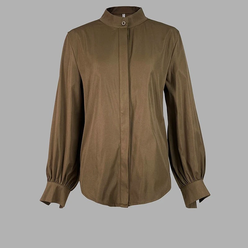 Klassisk damebluse med puffermer og knappedetaljer, tilgjengelig i grønn og brun.