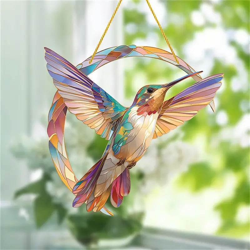 Hengende lilla kolibri i krystall, en fantastisk vindusdekorasjon som fanger lys og skaper regnbuer.