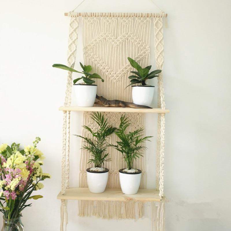 Bohemsk macramé hylle i beige/hvit med dekorative frynser, perfekt for interiørdesign og hjemmeinnredning.