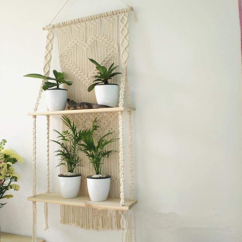 Beige/hvit macramé hylle med vakre frynser, elegant og bohemsk interiørdetalj for veggen.