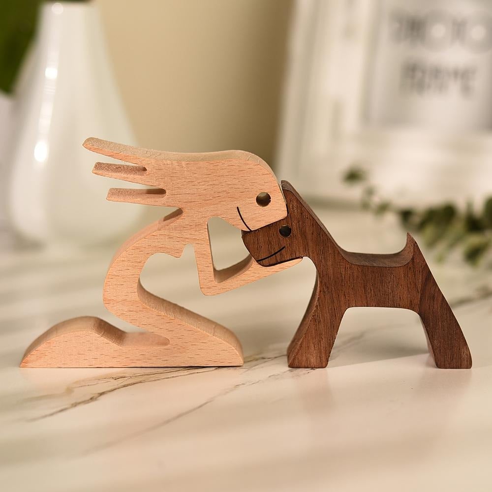 Detaljert håndskåret trefigur som viser et varmt bånd mellom eier og hund. Unik dyrefigur innredning.