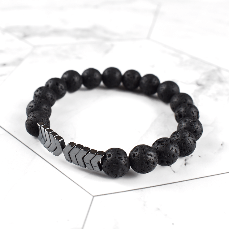 Detaljert bilde av Hellig Pil anhenget og de sorte lavasteinene i diffuser armbåndet.
