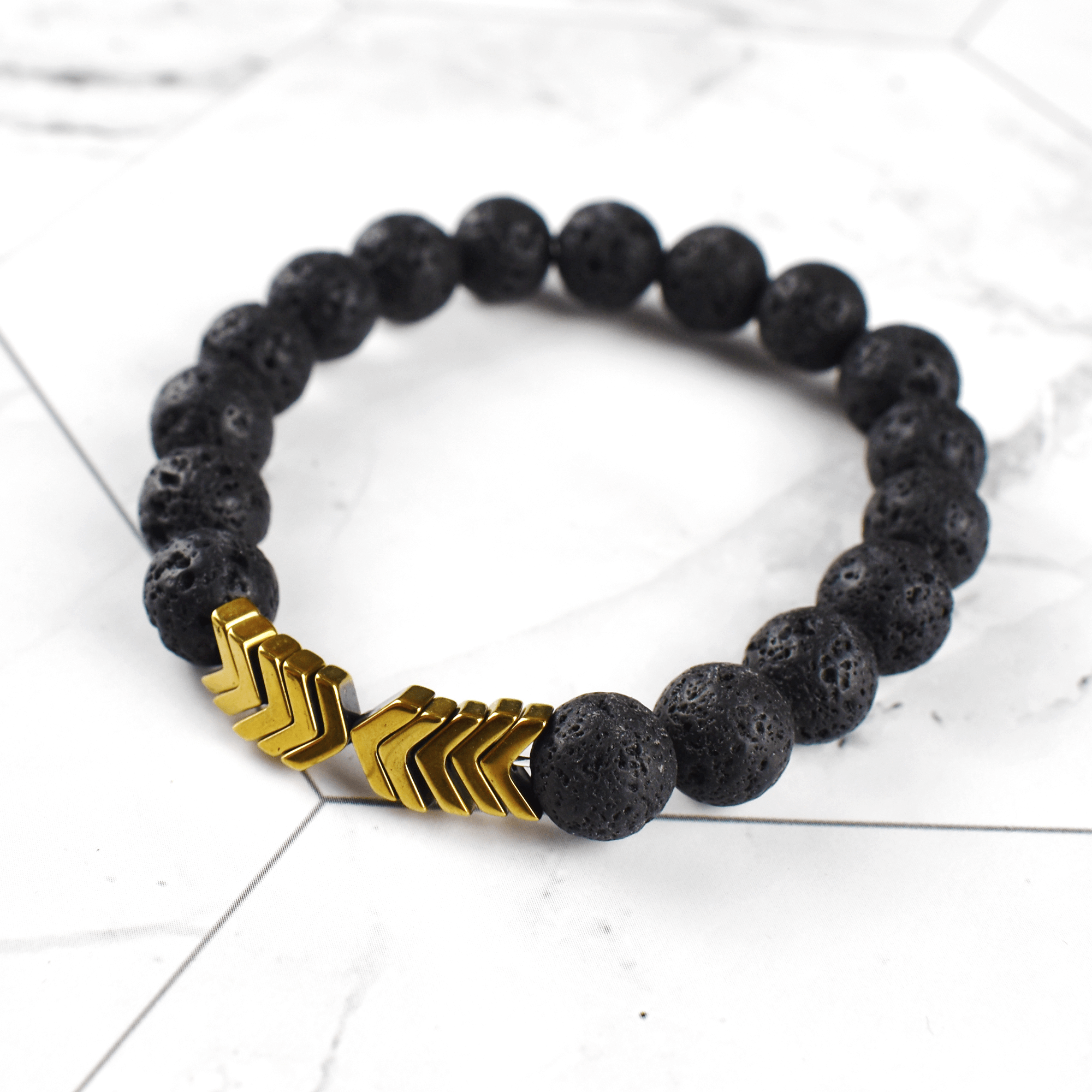 Nærbilde av Hellig Pil armbåndet; synlige lavasteiner for eteriske oljer og hematittkuler.