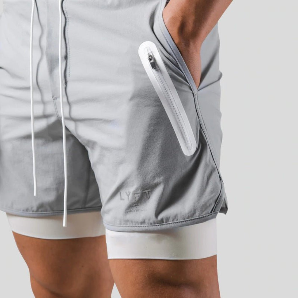 Sporty herre 2-i-1 shorts med lommer for mobil. Kompresjon for løping og fitness. Pustende.