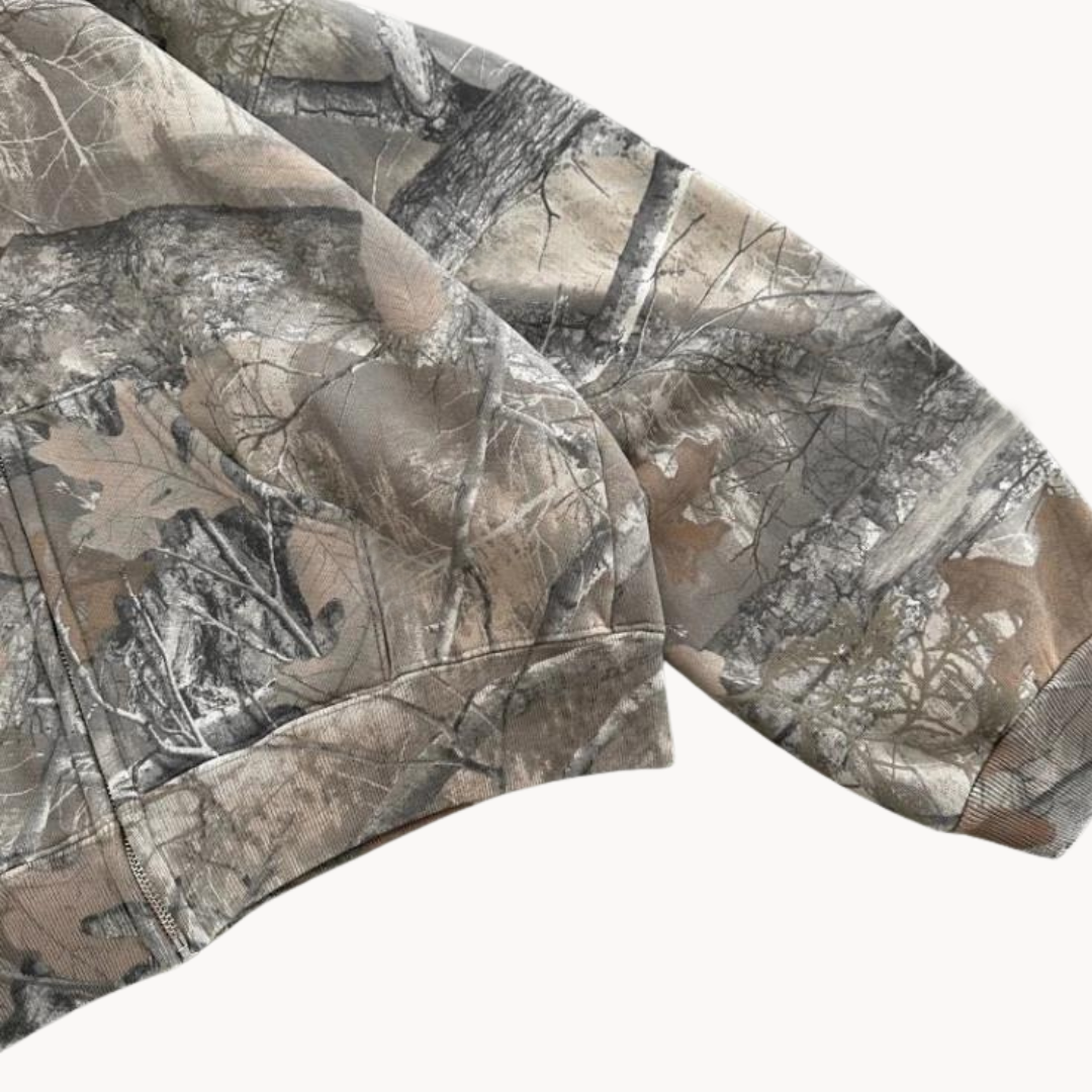 Nærbilde av grå kamuflasje print på en oversized herre hettegenser, med fokus på kvalitet og detaljer.